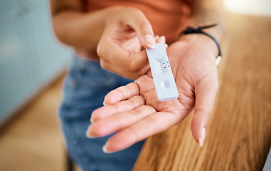 Image showing Woman hands holding a covid test for safety, healthcare and medicare with a negative result. Closeup of a rapid coronavirus antigen testing kit for a medical diagnosis exam with a pcr device at home.