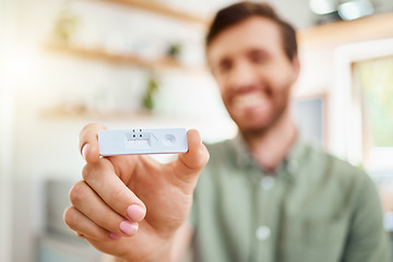 Image showing Test, covid and positive with the hand of a man holding a testing kit and result in his home. Healthcare, medical and health with a male in his house with the corona virus, sickness or covid 19