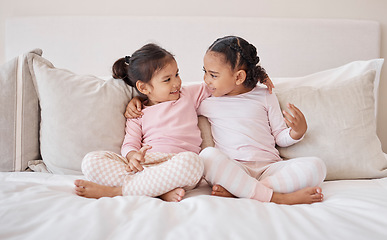 Image showing Happy kids, girls and friends together on the bed holding each other with a smile for friendship at home. Little girl children in friendly sister love and caring relationship smiling in the bedroom