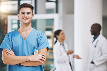 Image showing Portrait of a male nurse with his team in the background in the hospital. Happy, smiling and confident nurse with doctors in medicine, health and medical care. Medical team, healthcare and nursing