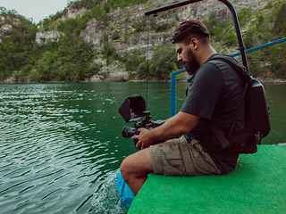 Image showing A videographer recording a group of friends kayaking together and exploring river canyons