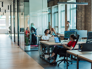 Image showing A diverse group of young business individuals congregates in a modern startup coworking center, embodying collaborative innovation and a dynamic atmosphere