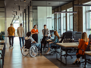 Image showing A diverse group of young business individuals congregates in a modern startup coworking center, embodying collaborative innovation and a dynamic atmosphere