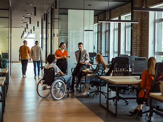 Image showing A diverse group of young business individuals congregates in a modern startup coworking center, embodying collaborative innovation and a dynamic atmosphere