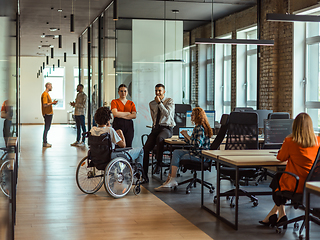 Image showing A diverse group of young business individuals congregates in a modern startup coworking center, embodying collaborative innovation and a dynamic atmosphere