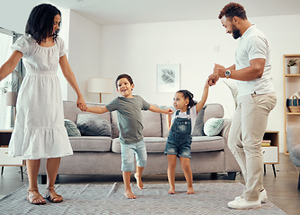 Image showing Happy family, dancing and having fun while sharing love, energy and bond while holding hands in the living room at home. Man, woman and sibling kids playing and laughing enjoying active time together