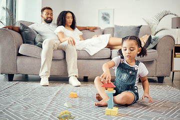 Image showing Child, development and toy blocks while learning motor skill and colors while building a tower in lounge at home with parents or adult supervision. Girl kid playing and fun with educational activity
