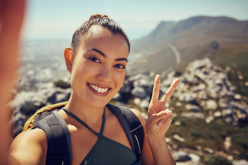 Image showing Hiking selfie, happy woman and fitness in nature on a mountain for exercise, travel and trekking adventure during summer. Face, smile and peace sign female tourist exploring outdoors with a backpack