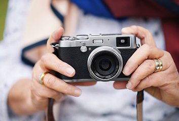 Image showing Retro camera, photography and travel with hands of a senior woman taking pictures while traveling, exploring and on an adventure. Closeup of retirement vacation, photographer and memories on holiday