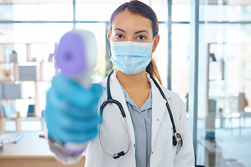 Image showing Covid compliance, medical doctor and woman with face mask and thermometer check for safety and protection before entry in a hospital. Portrait of healthcare worker treating coronavirus