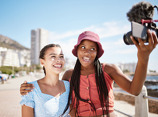 Image showing Influencer woman friends on beach live streaming beach holiday or vacation for social media in city, summer and blue sky. Gen z girl couple or people in selfie portrait or outdoor podcast near ocean