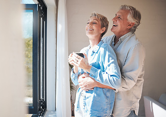 Image showing Retirement, coffee and window with couple in the morning happy and laughing for health, wellness and love together. Hug, marriage and peace with elderly man and old woman drinking tea at home