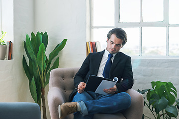 Image showing Young businessman reading paperwork, on couch at home and looking at financial analysis document for career development. Business finance report, changes in economy and success with accounting audit