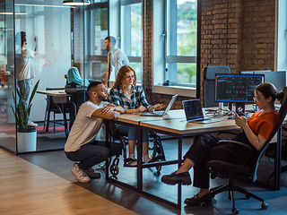 Image showing A diverse group of young business individuals congregates in a modern startup coworking center, embodying collaborative innovation and a dynamic atmosphere