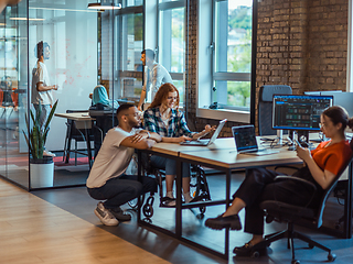 Image showing A diverse group of young business individuals congregates in a modern startup coworking center, embodying collaborative innovation and a dynamic atmosphere