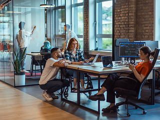 Image showing A diverse group of young business individuals congregates in a modern startup coworking center, embodying collaborative innovation and a dynamic atmosphere