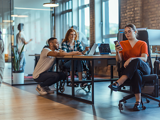 Image showing A diverse group of young business individuals congregates in a modern startup coworking center, embodying collaborative innovation and a dynamic atmosphere