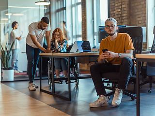 Image showing A diverse group of young business individuals congregates in a modern startup coworking center, embodying collaborative innovation and a dynamic atmosphere