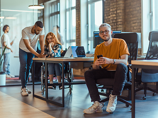 Image showing A diverse group of young business individuals congregates in a modern startup coworking center, embodying collaborative innovation and a dynamic atmosphere