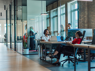 Image showing A diverse group of young business individuals congregates in a modern startup coworking center, embodying collaborative innovation and a dynamic atmosphere