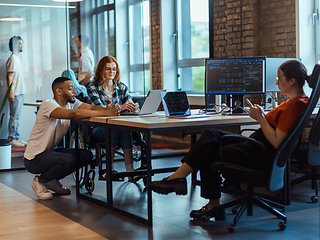 Image showing A diverse group of young business individuals congregates in a modern startup coworking center, embodying collaborative innovation and a dynamic atmosphere