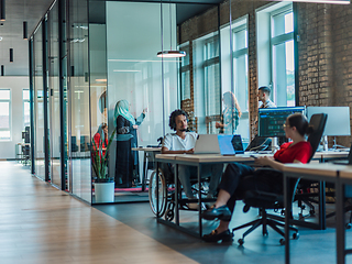 Image showing A diverse group of young business individuals congregates in a modern startup coworking center, embodying collaborative innovation and a dynamic atmosphere