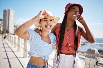 Image showing Summer, fashion and gen z girl friends in the city near the beach or ocean for holiday, vacation or youth wellness. Vitamin d, happiness and love with young women wearing hat outdoor in the sunshine