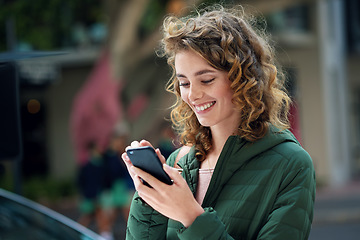 Image showing Happy woman, smile and typing on phone during travel in city using social media, internet and 5g network connection outside. Young female flirting on a mobile app for communication on urban street