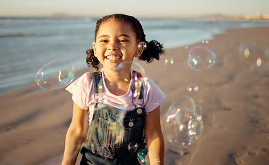 Image showing Beach, bubbles and a girl playing at sunset, having fun and enjoying an ocean trip. Freedom, energy and child running alone the sea, excited and playful while chasing bubble and laughing in nature