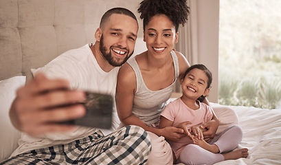 Image showing Phone selfie of a relax happy family in bed, bond and enjoy quality time together in home bedroom. Love, morning and happiness for fun couple in pajamas bonding with adopted youth child, kid or girl