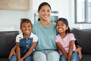 Image showing Happy, smile and portrait of a mother and children sitting on a sofa at home in Indonesia. Happiness, love and mom embracing her girl kids while relaxing on a couch together in their living room.