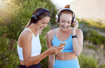 Image showing Headphones, phone and fitness women in nature music, radio or audio streaming during exercise. Health, wellness and happy athlete girls on mobile, social media or 5g tech, workout app and training.