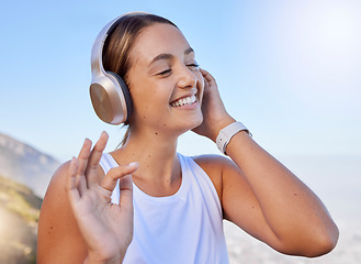 Image showing Music streaming, fitness headphones and web radio of a woman athlete listening to a song in nature. Happy smile after a workout on the mountain with blue sky and happiness relax hearing a track