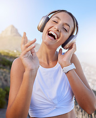 Image showing Fitness, headphones and woman outdoor listening to music for wellness podcast while training or doing workout exercise on blue sky and lens flare. Young person with 5g audio for exercise on mountain