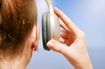 Image showing Hands of woman with headphones listening to music for peace of mind, freedom and relax outdoor back view. Podcast, radio and calm girl streaming rock, disco or jazz audio song for wellness mindset