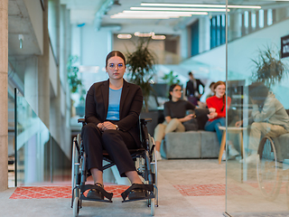 Image showing In a modern office, a young businesswoman in a wheelchair is surrounded by her supportive colleagues, embodying the spirit of inclusivity and diversity in the workplace