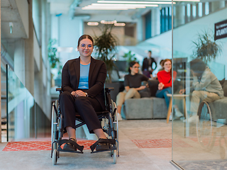 Image showing In a modern office, a young businesswoman in a wheelchair is surrounded by her supportive colleagues, embodying the spirit of inclusivity and diversity in the workplace