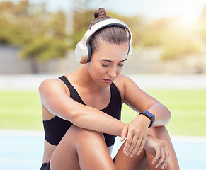 Image showing Sport runner woman listening to music on break from training, exercise and fitness workout. Tired athlete rest to recover from pain, prevent muscle injury and physical exhaustion or medical emergency