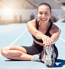 Image showing Happy fitness or sports woman stretching at stadium in sunshine lens flare for healthy lifestyle and wellness motivation. Young athlete runner on ground outdoor in trainer shoes for exercise training