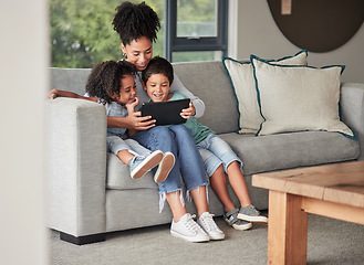 Image showing A mother with children on couch with tablet to watch educational shows and streaming music. Foster or adoption parent with kids in living room watch cartoons, playing online games and homeschooling.