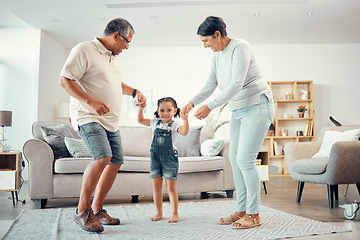 Image showing Happy grandparents, girl and dance holding hands in home living room with music having fun sharing love, energy and bond. Retired man, woman and kid playing, caring and enjoying active time together.