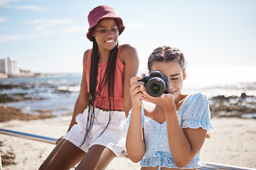 Image showing Summer, beach and photographer with camera, young girl taking a photograph. Friends, fun and happy teenagers on holiday by the sea with a scenic ocean view. Portrait of girls, photography and nature