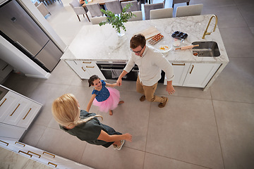 Image showing Family, children and dance with a girl and her parents dancing together in the kitchen of their home. Smile, fun and playful with a female child, her mother and father feeling happy in their house