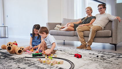 Image showing Happy family, bonding and children playing in living room, relax and cheerful in their home together. Loving parents smile and enjoy parenthood, watching kids play on a floor while resting on couch