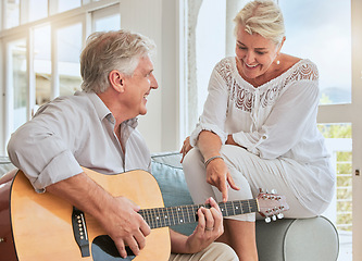 Image showing Old couple, guitar and love in home, sofa or couch playing a romantic, lovely or affection musical song for wife. Romance, retired senior man and woman play acoustic string instrument in living room.