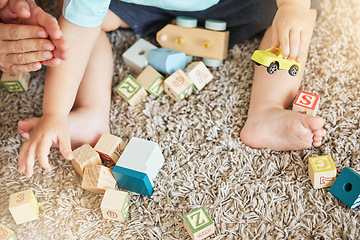 Image showing Closeup of baby learning with toys, block puzzle and train to help hand eye coordination on floor in home. Young child learn with education games on carpet, for cognitive development and fun in house