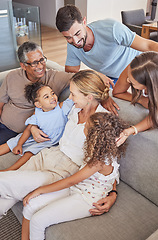 Image showing Happy interracial family bonding with their children and grandparents at home. Adults and their kids smile while sitting on the sofa, laugh and hug in a living room during vacation in a holiday house