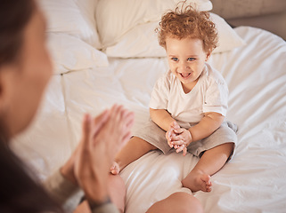 Image showing Baby, family and child clapping hands, happy and having fun on bed playing with his mother at home. Cute kid, son or toddler boy clap for mobility development and bonding while laughing with woman