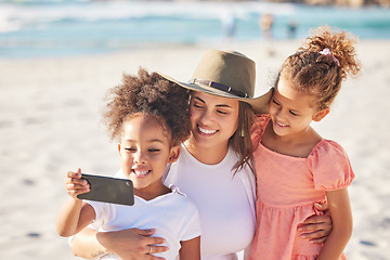 Image showing Mom, children and beach with phone for selfie in the sunshine while on holiday together. Mother, kids and ocean take photo with smartphone in the sun on vacation or family travel to the sea