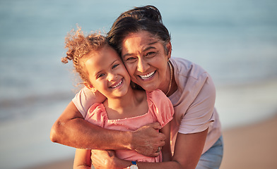 Image showing Portrait of grandmother and child at the beach on holiday, smiling and having fun. Senior woman with grandchild, hugging her by the ocean during sunset. Summer, vacation and family holiday at the sea